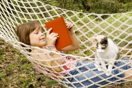 Seven years old reading in a hammock with her cat on her lap.More atBest friends Lightbox:
